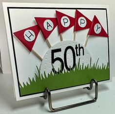 a birthday card with red and white pennants on it, sitting on a metal holder