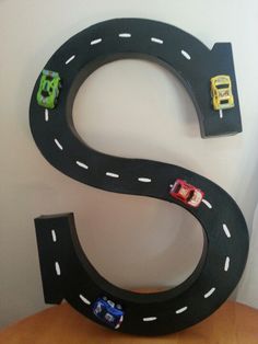 the letter s is made out of cardboard and has cars on it