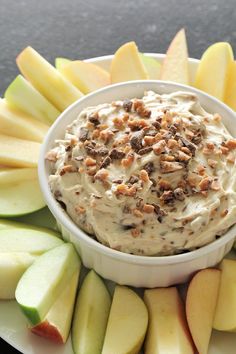 a white plate topped with an apple and walnut dip