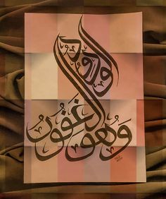 an arabic calligraphy is displayed on a piece of paper that has been folded over