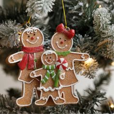 two gingerbread men ornament hanging from a christmas tree