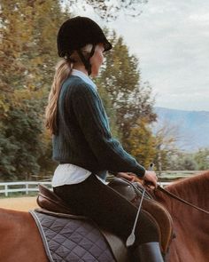 a woman riding on the back of a brown horse