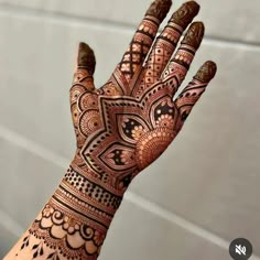 the hand is decorated with henna designs on it's fingers and palmes