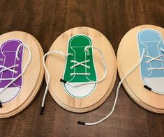 three wooden coasters with different colored shoes on the top and bottom one is white, green, purple, and blue