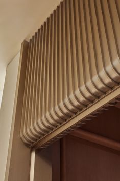 a close up view of the top of a wooden closet door with metal slats on it