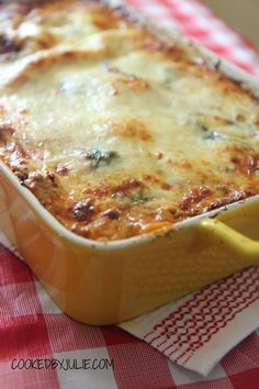 a cheesy casserole dish on a red and white checkered tablecloth