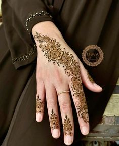 a woman's hand with henna tattoos on it