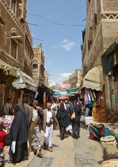 people are walking through an open market area