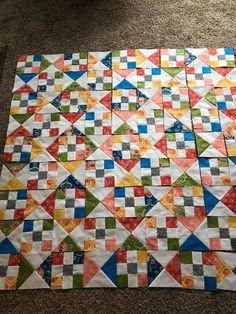 a colorful quilt is laying on the floor