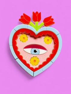 a heart shaped box with an eye and flowers on the inside, against a pink background