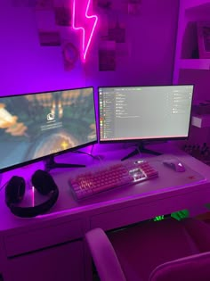 two computer monitors sitting on top of a desk next to a keyboard and headphones