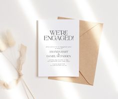 a wedding card with the words we're engaged on it next to some dried flowers