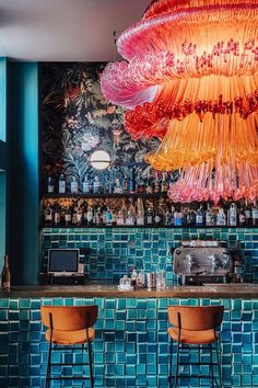 the bar is decorated with colorful lights and chandelier hanging from the blue wall