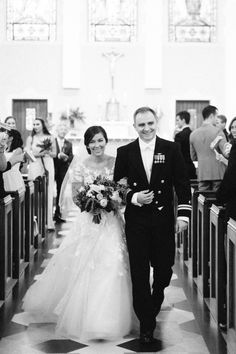 a bride and groom walking down the aisle