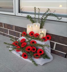 some red flowers and candles on a towel