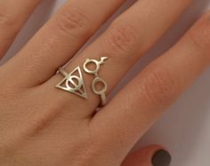 a woman's hand wearing a ring with an eye and triangle design on it