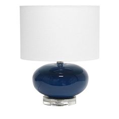 a blue glass table lamp with a white shade on the top and bottom part of it