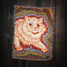 a colorful cat tapestry hanging on a wooden wall