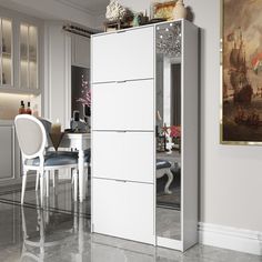 a white cabinet sitting in the middle of a living room next to a dining room table