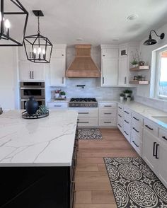 a large kitchen with white cabinets and marble counter tops, along with an area rug on the floor