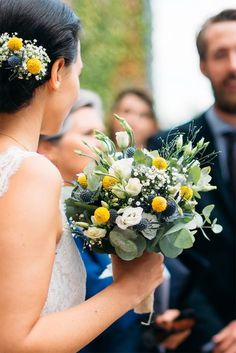 a woman holding a bouquet of flowers next to a man