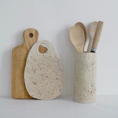 two ceramic utensils and a wooden cutting board