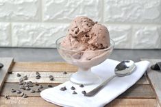 a bowl filled with chocolate ice cream on top of a wooden table