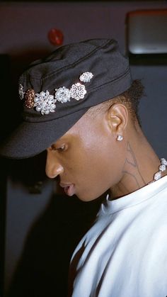 a young man wearing a black hat with flowers on it