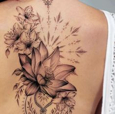 the back of a woman's shoulder with flowers and leaves on her left side