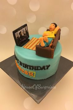 a birthday cake that is shaped to look like a couch with a person sitting on it