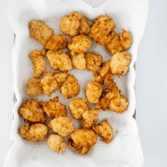 some fried food is in a paper bag on a white tablecloth and it looks like something out of the box