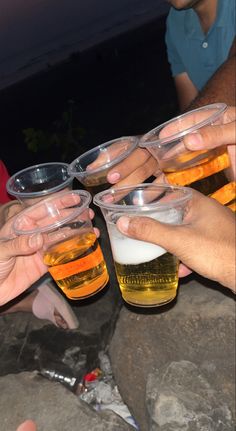 several people are holding their glasses full of beer