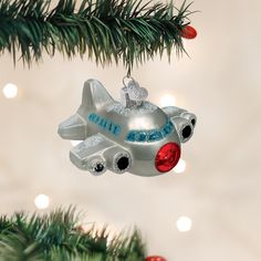 a silver ornament shaped like an airplane hanging from a christmas tree