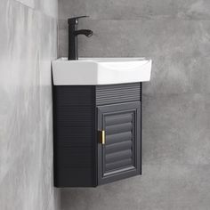 a bathroom sink with a black cabinet and white counter top next to a gray wall