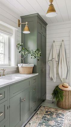 a bathroom with green cabinets and rugs on the floor in front of sink area