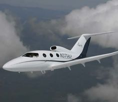 a small white plane flying through the sky