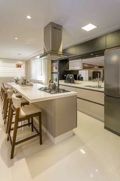 a kitchen with an island, stove and refrigerator in it's center area is shown