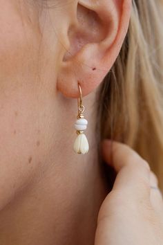 These dainty Pikake Puka shell drop earrings exude Hawaii's natural beauty. These gold earrings feature natural puka shells and carved pikake flower charms reminiscent of Hawai'i's flower leis. They are perfect solo or teamed with our other earrings. ✦ DETAILS ✦ ✧ Name: Kēhau (keh-how) - dewdrop. ✧ 14kt Gold Filled w/carved resin Pikake flowers and natural Puka shells. ✧ 3cm Drop Length ✧ All Ke Aloha Jewelry pieces come packaged thoughtfully, beautifully, and ready for gift giving. ✦ MORE EARRI Hawaiian Shell Jewelry, Cream Teardrop Earrings For Gift, Delicate White Teardrop Earrings, Adjustable Cream Drop Earrings, White Feminine Everyday Earrings, Feminine White Everyday Earrings, White Teardrop Earrings Feminine Style, White Teardrop Feminine Earrings, Beige Dangle Earrings With Ear Wire