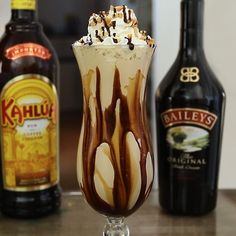 an ice cream sundae in a tall glass with whipped cream and caramel on top