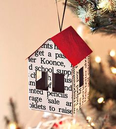 a house shaped ornament hanging from a christmas tree with words written on it