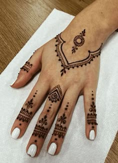 a woman's hand with henna tattoos on it