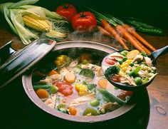 a bowl of soup with carrots, celery and corn on the side