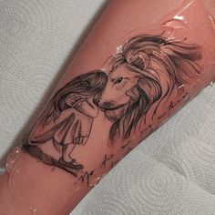 a lion tattoo on the arm of a woman's left leg with an angel