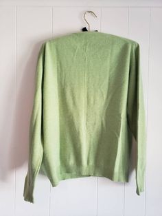 This is a vintage cardigan sweater. It is green, long sleeved and has Mother of Pearl buttons. I do not know its size as there is no label. Please refer to the measurements for a proper fit. I think this sweater is possibly lambswool or angora. I am not sure due to the missing label. Please note, there are 2 or 3 spots that are a bit dark. I dont think these are stains, just little dark marks in the fibers. They are evident in the 4th and 5th pictures. Please feel free to ask to see an image. Th Green Cotton Long Sleeve Cardigan, Green Long Sleeve Cardigan, Green Fitted Long Sleeve Cardigan, Classic Green Cotton Cardigan, Green Crew Neck Winter Cardigan, Green Crew Neck Cardigan For Winter, Green Crew Neck Cardigan For Fall, Retro Green V-neck Sweater, Vintage Solid Color Winter Cardigan