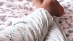 a person laying on top of a bed covered in blankets