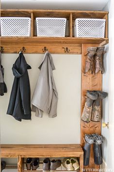 a coat rack with several coats and shoes hanging on the wall next to it is an entryway