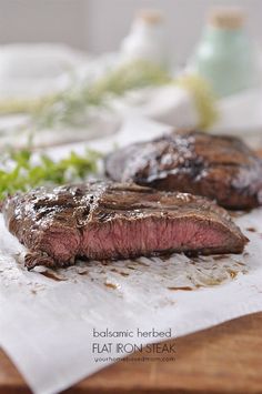 two steaks sitting on top of a wooden cutting board