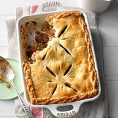 a close up of a pie in a pan on a table next to a fork