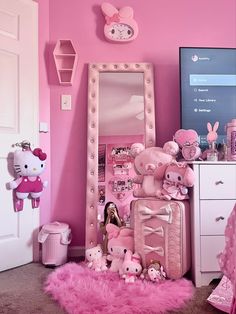 a pink room with hello kitty decorations on the wall