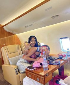 a woman is sitting on an airplane with her phone to her ear and luggage in front of her